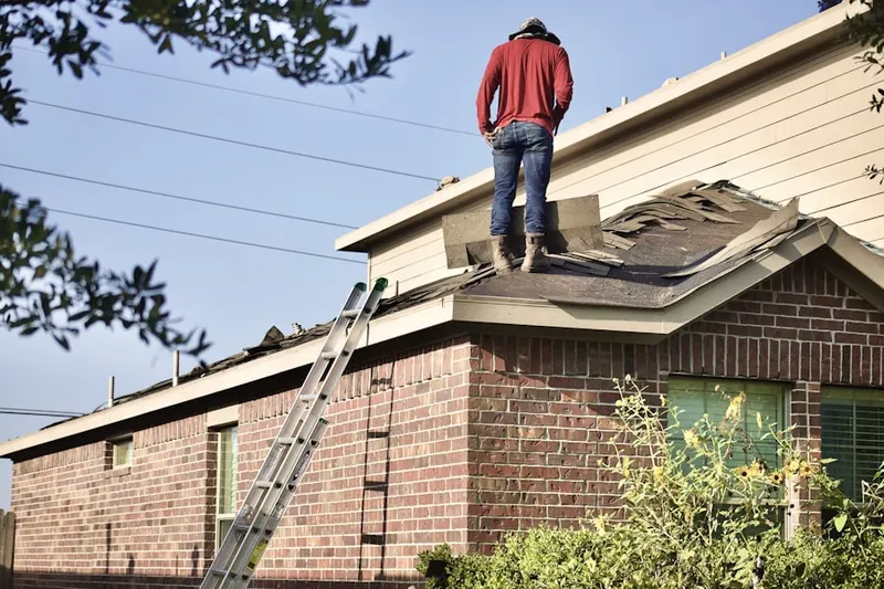 Professional roofer working on a residential roof in Harbor View Homes
